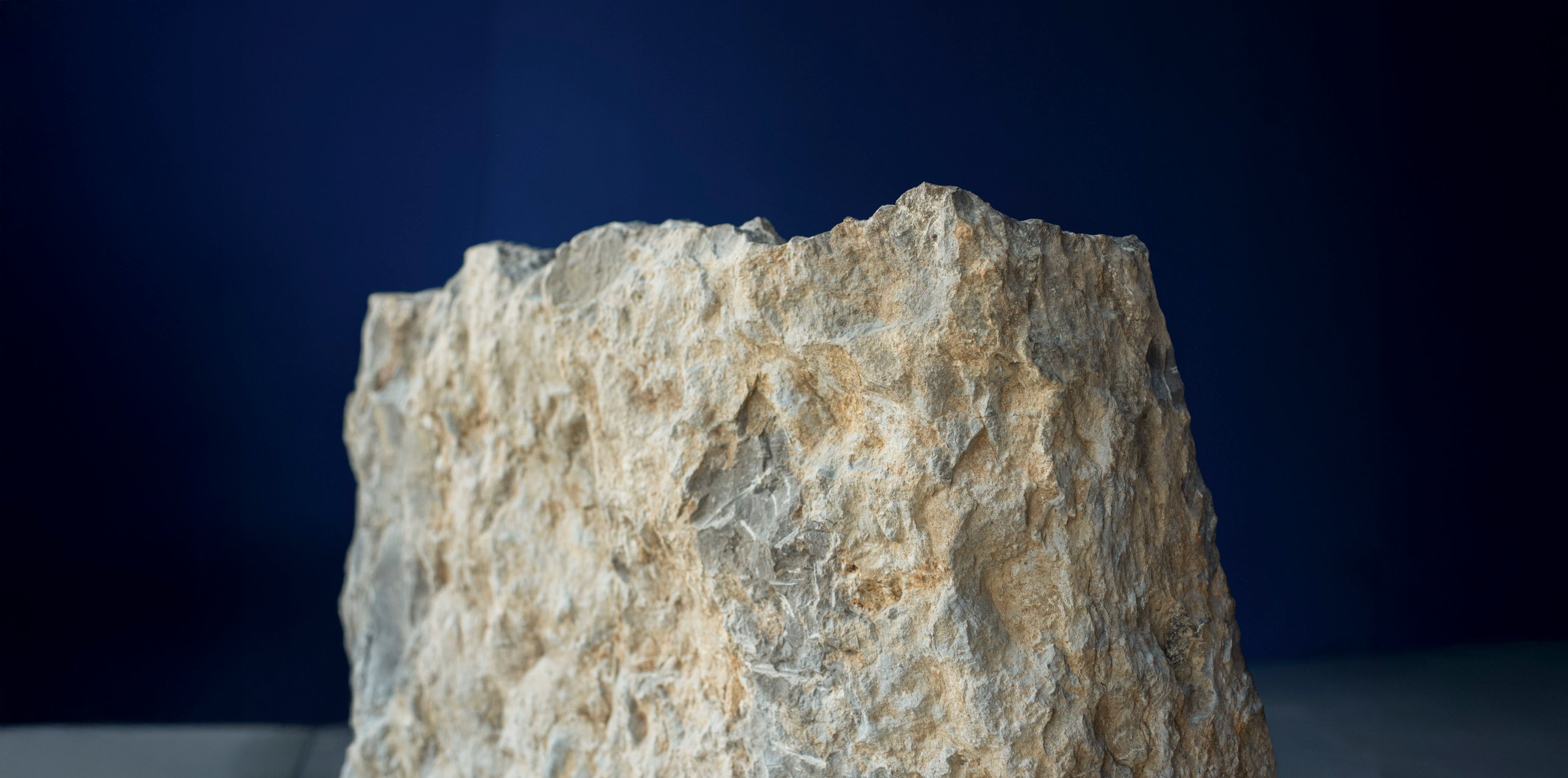 The split back of the stone against a deep blue wall