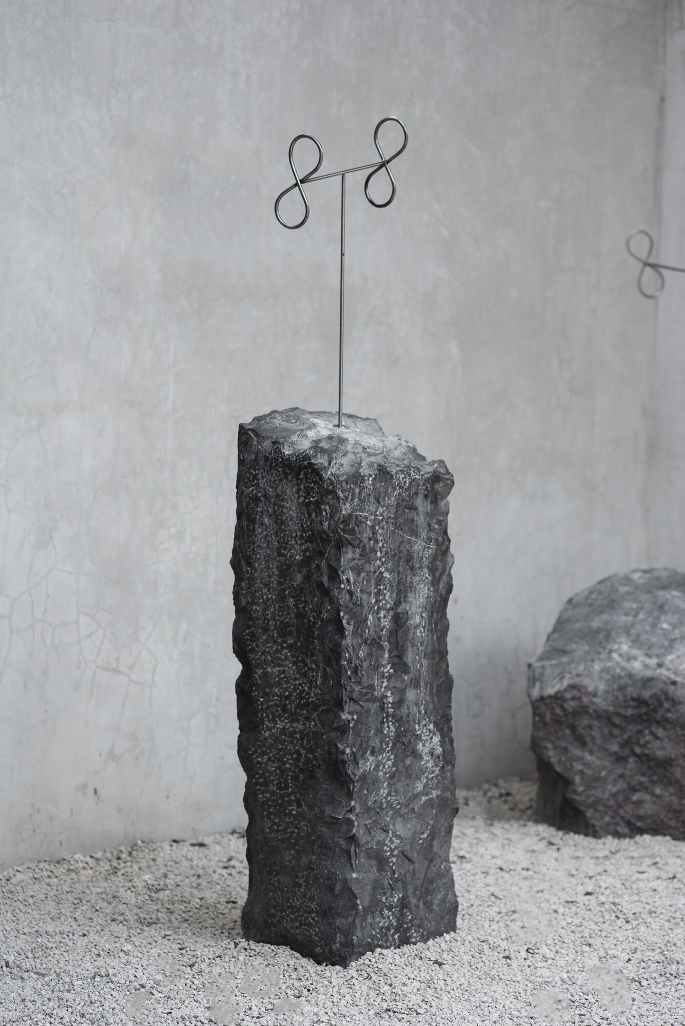 Sculpture III: a tall narrow marble block with steel post and loops